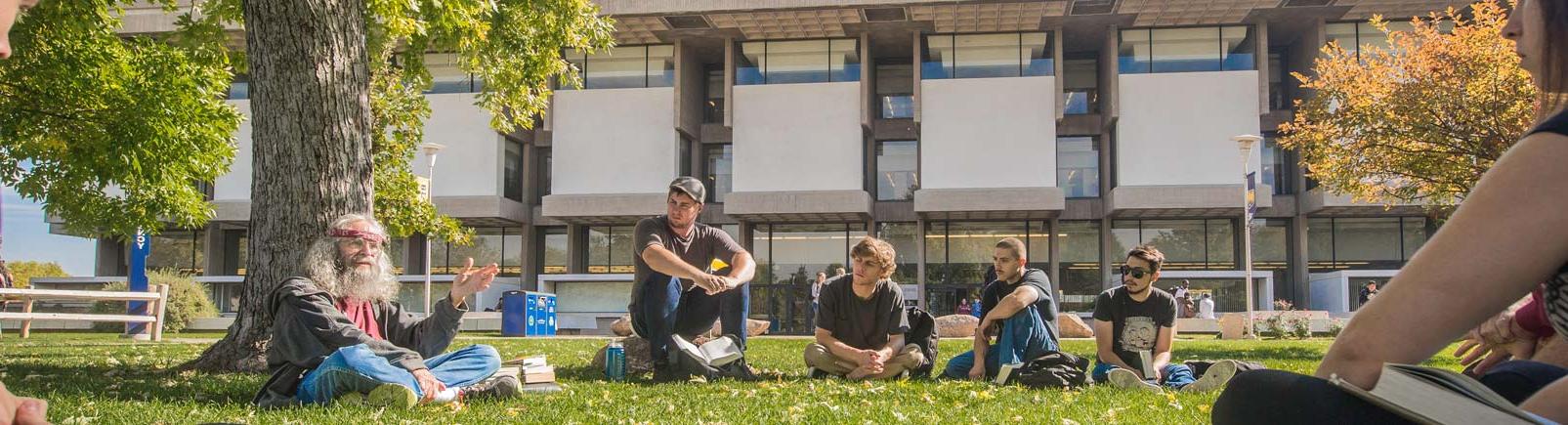 Students gathered under tree near 麦切纳库