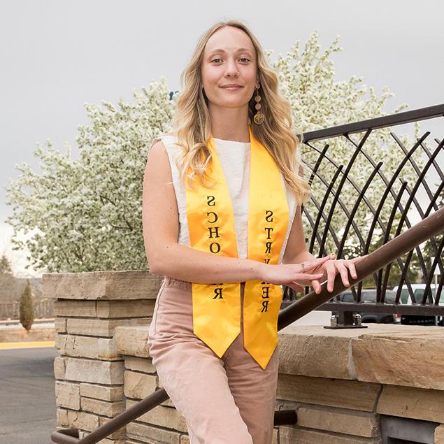 Madeline standing on stairs outside looking at the camera